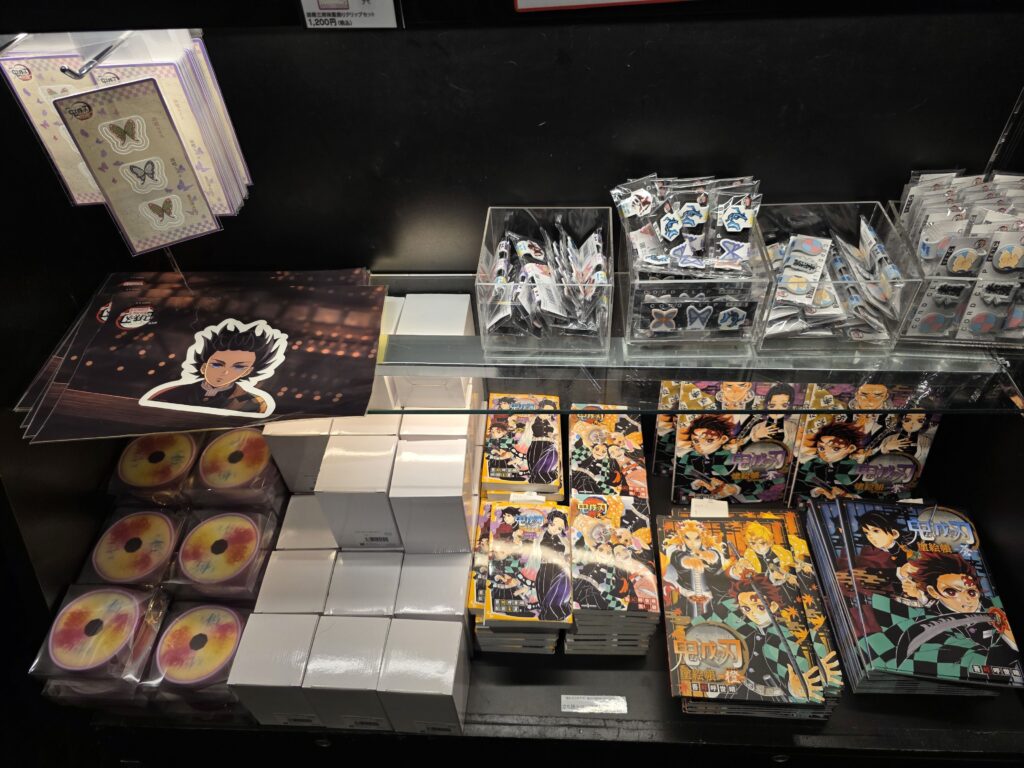 Demon Slayer manga, coloring books, and clip items on display