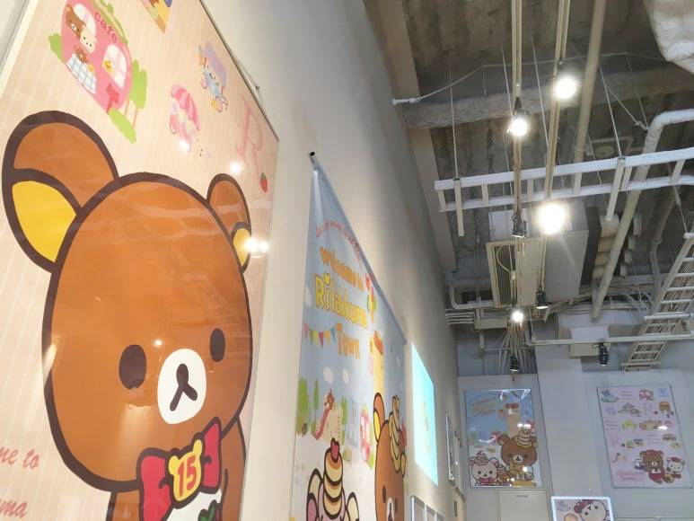 Inside the Rilakkuma Café in Osaka, with tall walls fully decorated with large character posters and banners up to the ceiling