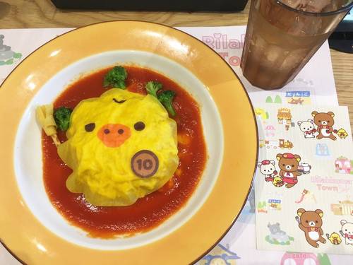 Kiiroitori-themed omurice topped with a yellow egg wrap shaped like the character, served in tomato sauce at the Rilakkuma Café in Osaka