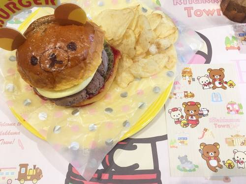 A Rilakkuma-themed cheeseburger with chips, featuring a bun decorated with Rilakkuma’s face and ears at the café in Osaka