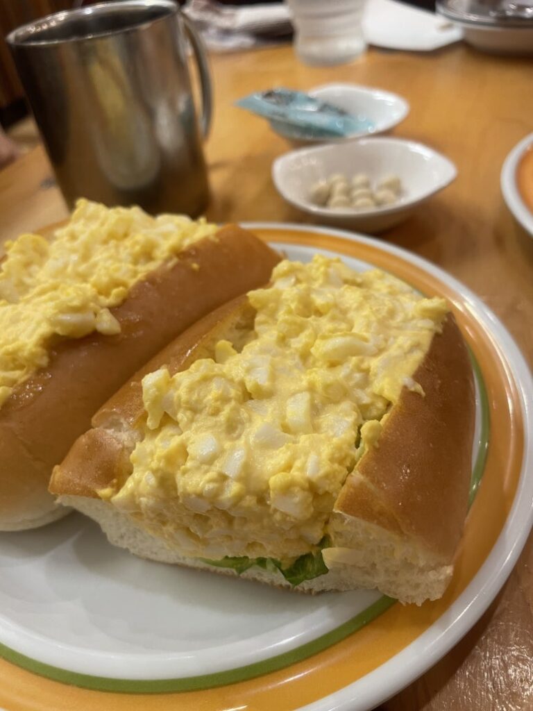 Close-up of Komeda Coffee’s egg hot dog with creamy egg filling