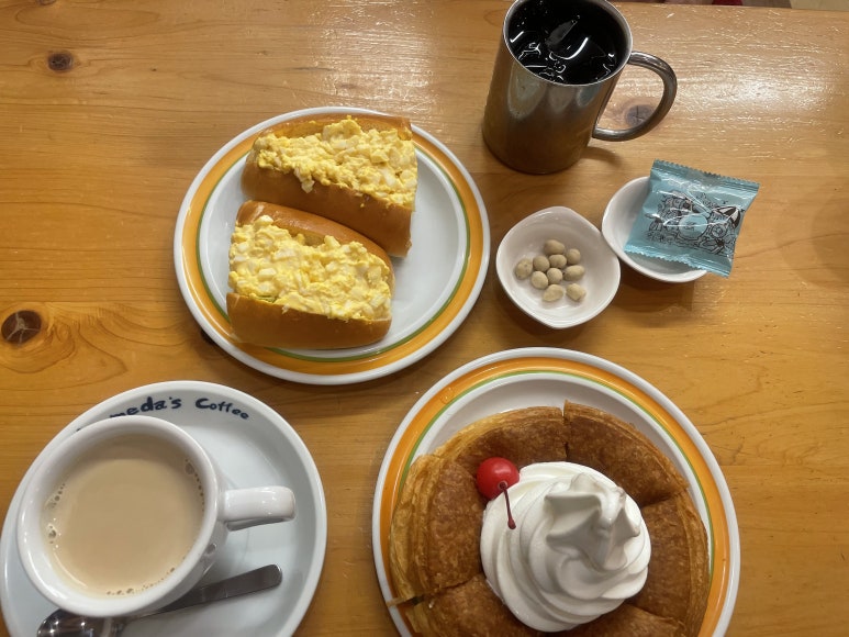 Komeda Coffee set with egg-filled hot dog, Shiro Noir dessert, and coffee
