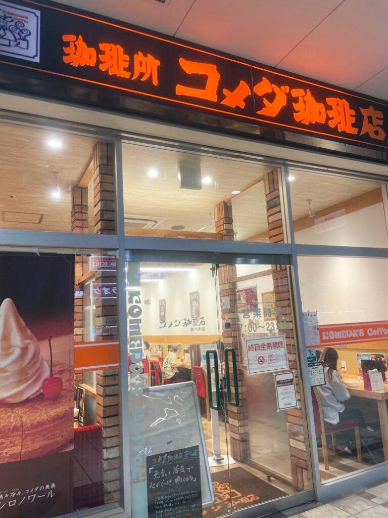Entrance of Komeda Coffee shop in Japan with visible signage and menu poster