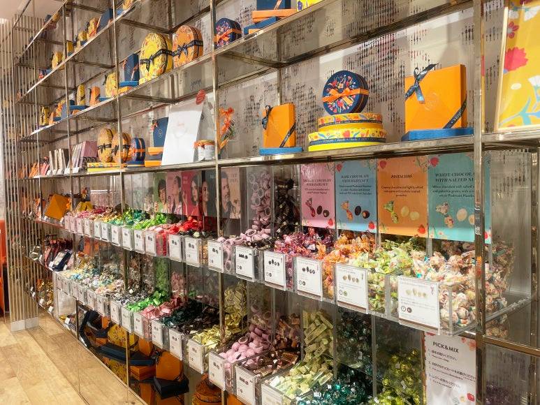 Wrapped Venchi chocolates and gift boxes on metal shelves