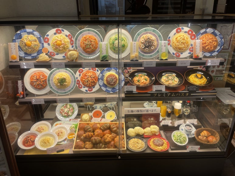 Plastic food display at Kamakura Pasta showing various pasta dishes and bread