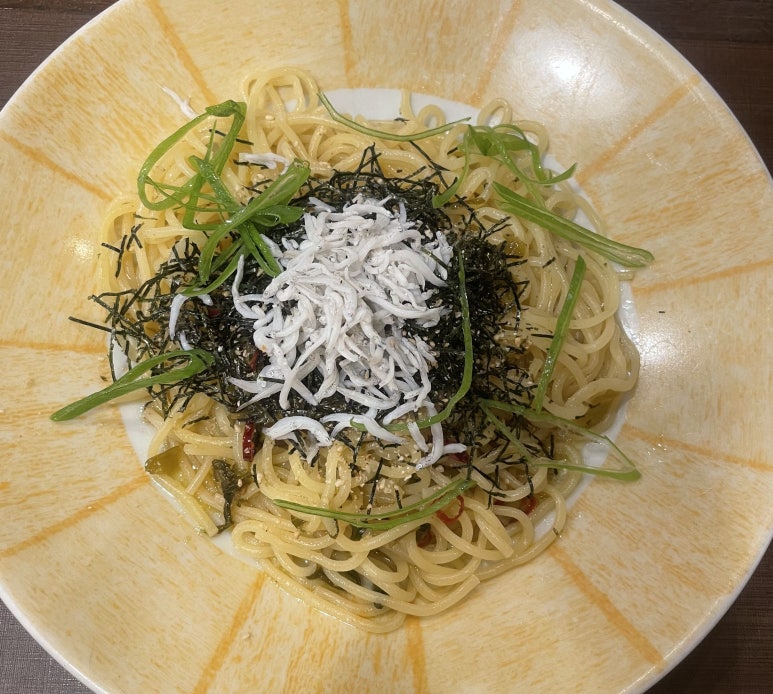 Spicy pasta topped with whitebait (shirasu), pickled takana greens, shredded seaweed, and green onions