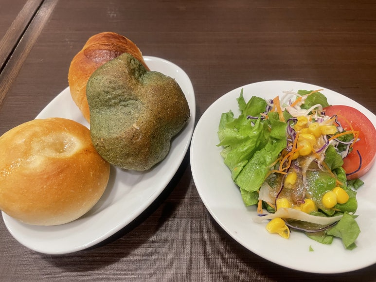 A plate of assorted bread and a fresh salad served at Kamakura Pasta
