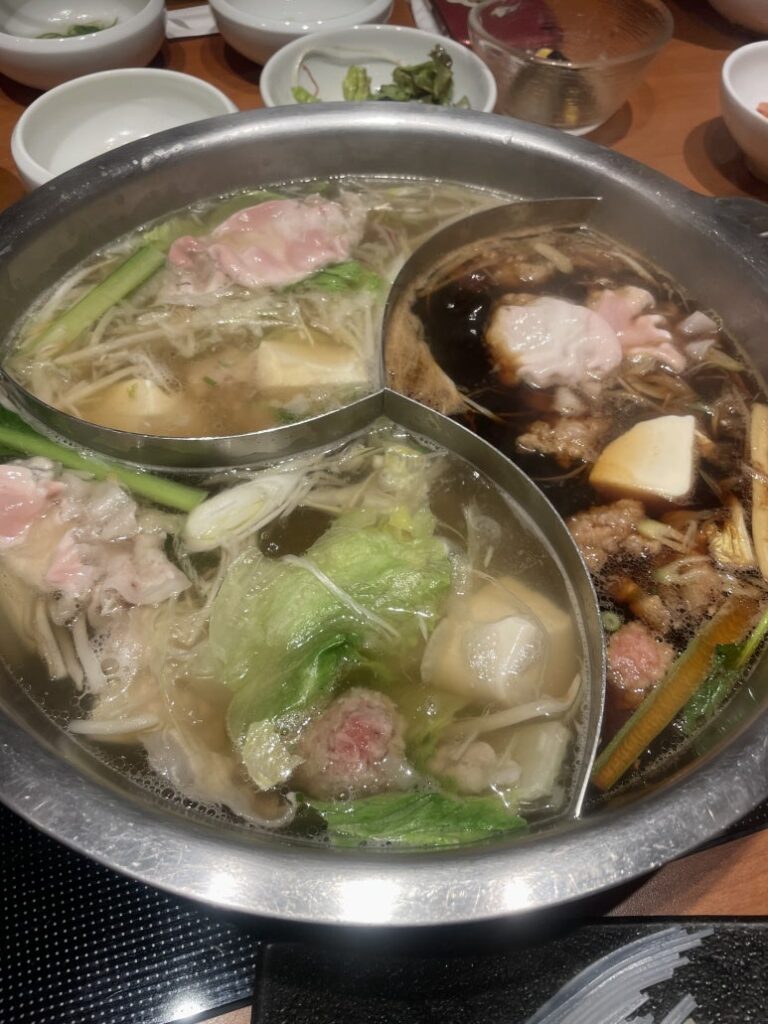 Three-section hot pot at Kinnobuta with meat and vegetables boiling in different broths