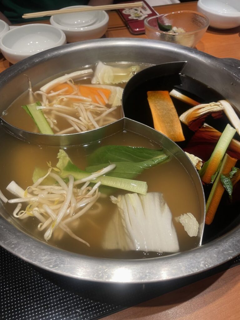 Three kinds of shabu-shabu broth in a divided hot pot at Kinnobuta
