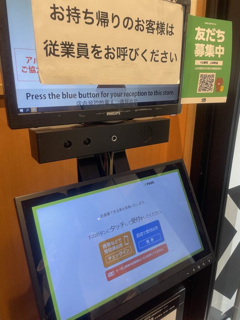 Ticketing machine at the entrance of Kura Sushi with touchscreen check-in system