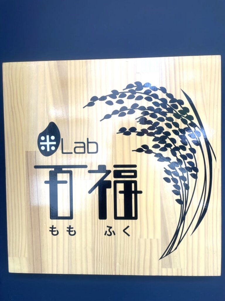 Wooden signboard of Momofuku with rice grain illustration