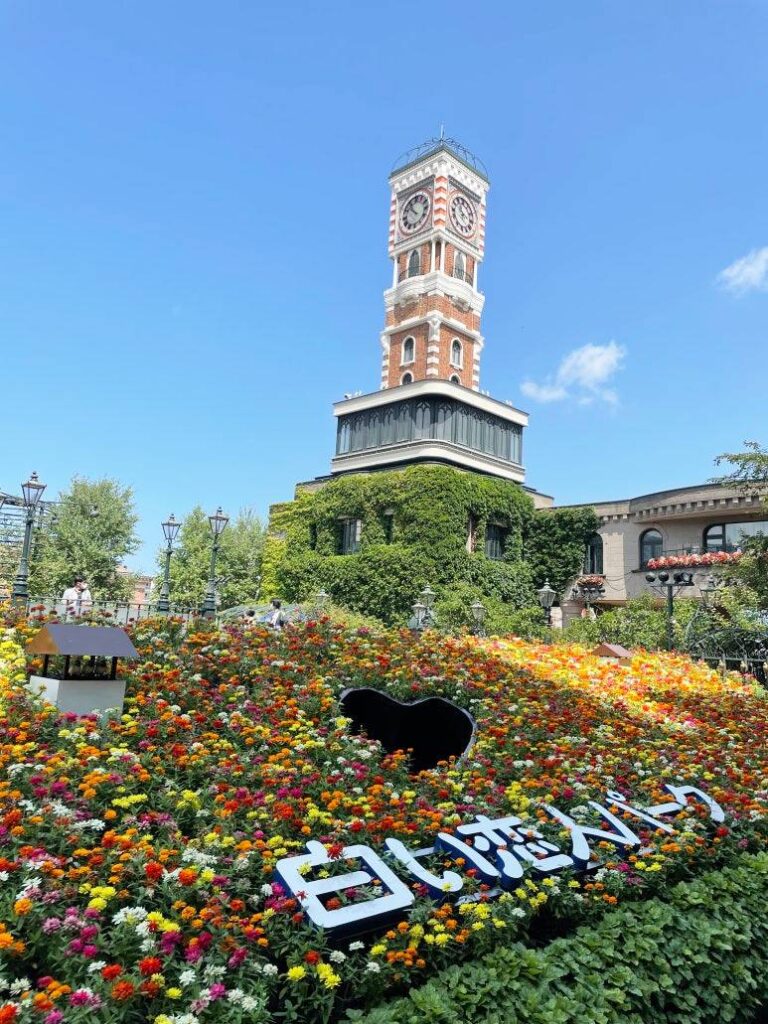 Clock tower and flowerbed at the entrance of Shiroi Koibito Park in Sapporo, Hokkaido.