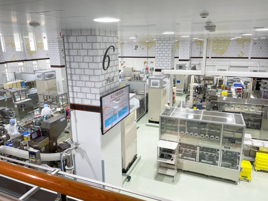 Inside the Shiroi Koibito cookie factory showing workers and production machines in operation