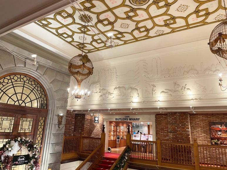 Elegant ceiling and wall reliefs inside Shiroi Koibito Park, featuring chandeliers and classic European decor.