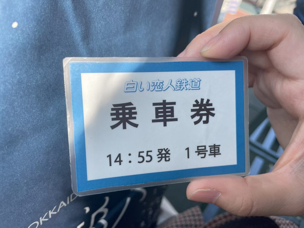 A boarding pass for the mini train ride at Shiroi Koibito Park, showing departure time and car number.