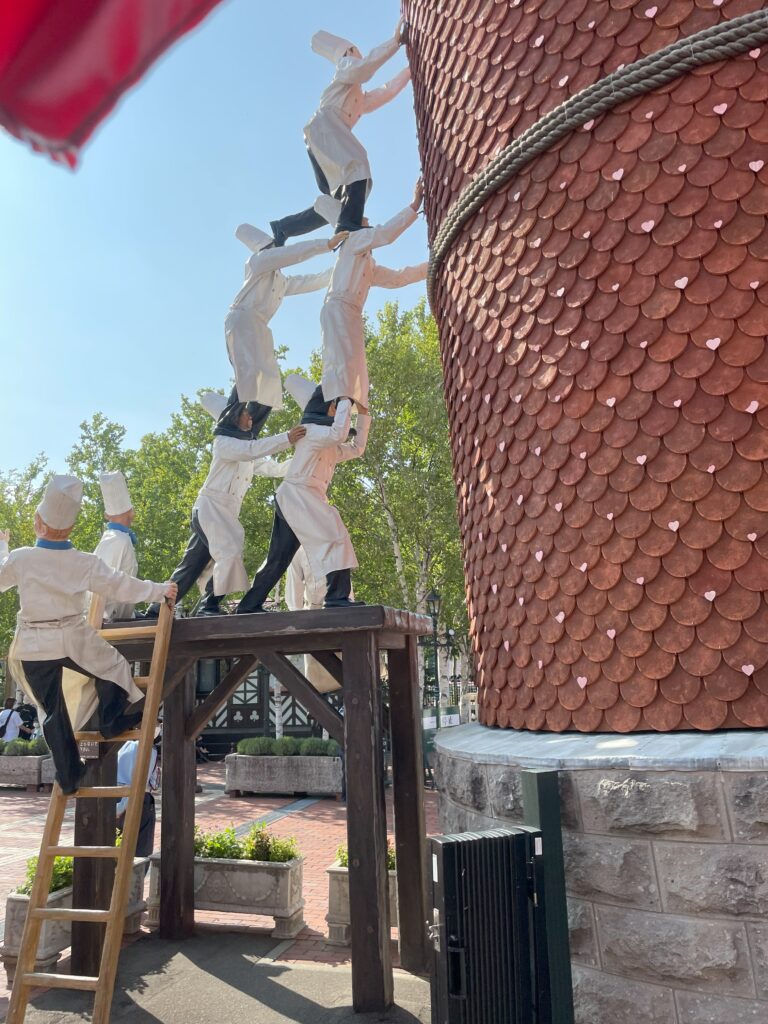 A playful sculpture of patissier figures supporting a large pillar at Shiroi Koibito Park.