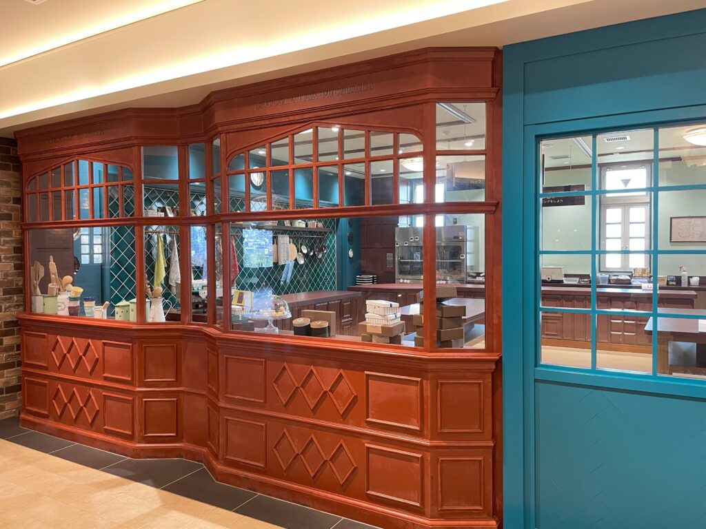 Exterior view of the “Sweets Workshop DREAM KITCHEN” at Shiroi Koibito Park, with baking tools visible through the window.