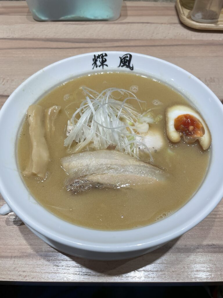 A bowl of rich miso ramen with chashu pork, seasoned egg, and green onions, served in Sapporo, Hokkaido