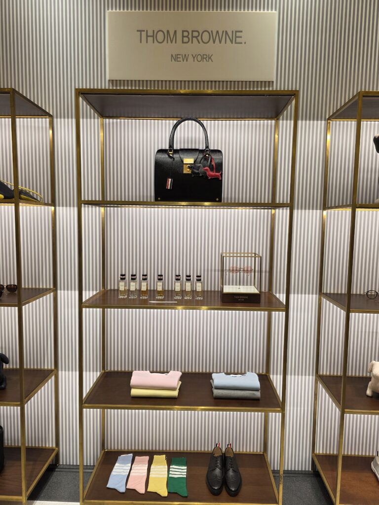 Center shelf featuring bags, fragrances, shirts, socks, and shoes