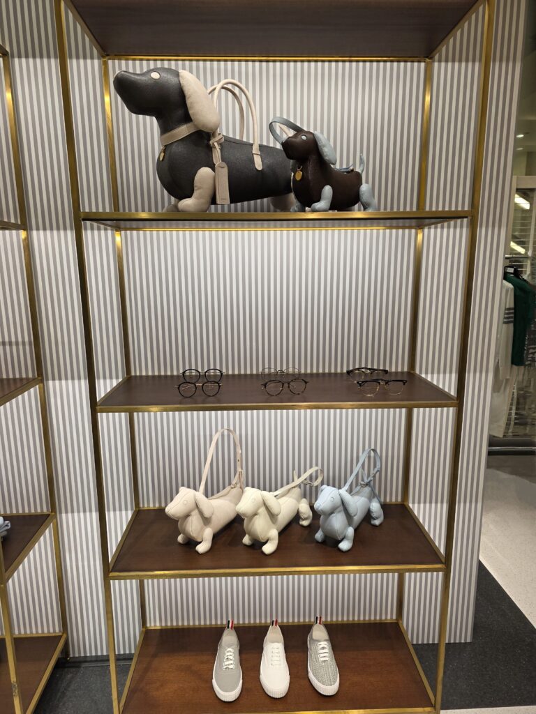 Shelf with Hector bags in various colors, eyeglasses, and sneakers