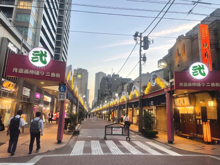 View of Tsukishima Monja Street entrance at dusk