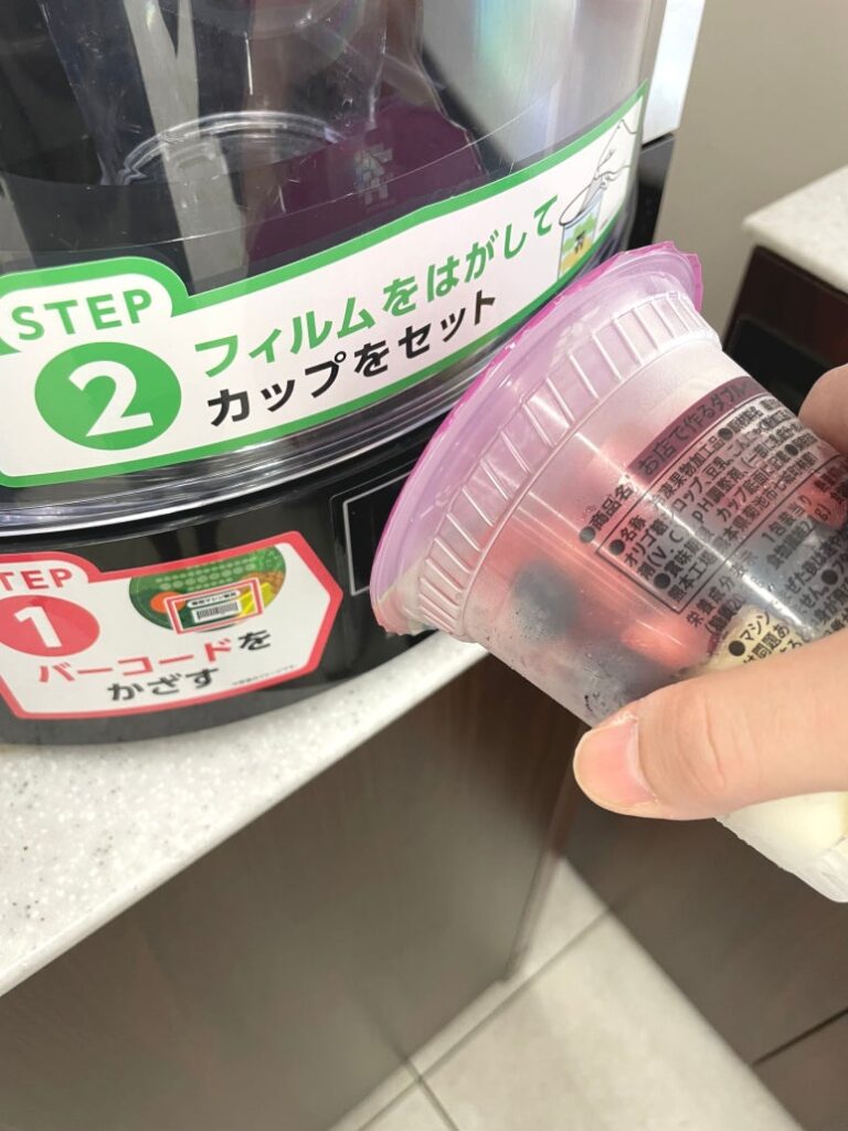 セブンカフェマシンでスムージーカップのバーコードをスキャンする様子