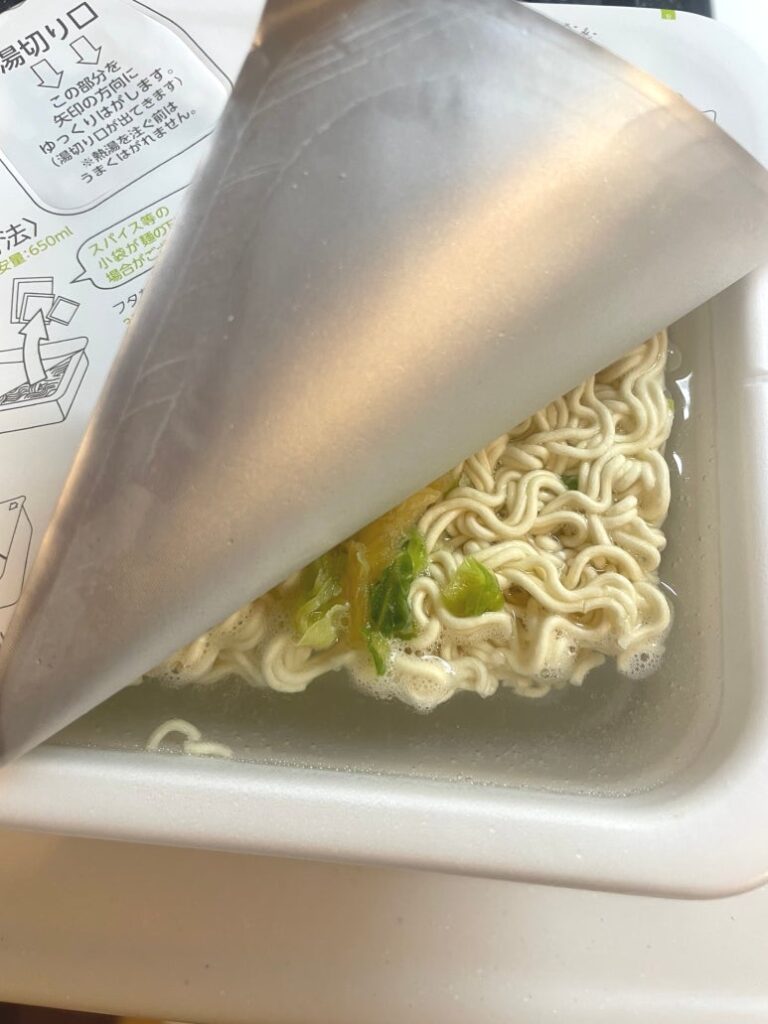 Pouring hot water up to the line for Japanese cup noodle Maruchan Gotsumori Shio Yakisoba