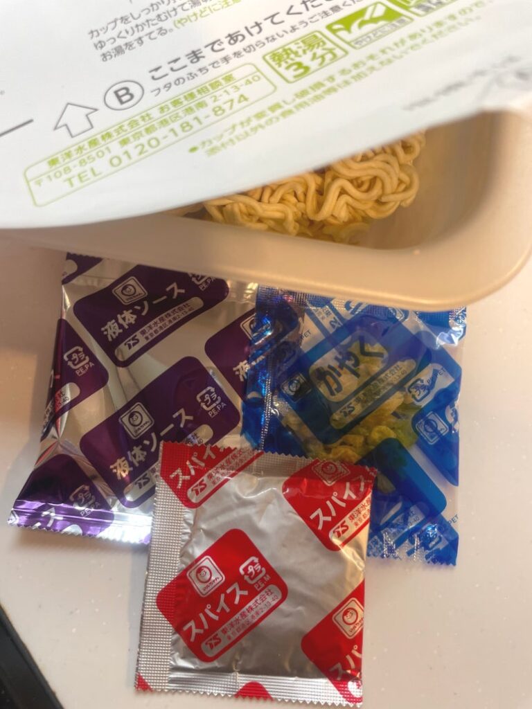 Three seasoning packets included in Japanese cup noodle Maruchan Gotsumori Shio Yakisoba, liquid sauce, dried ingredients, peppered spice mix