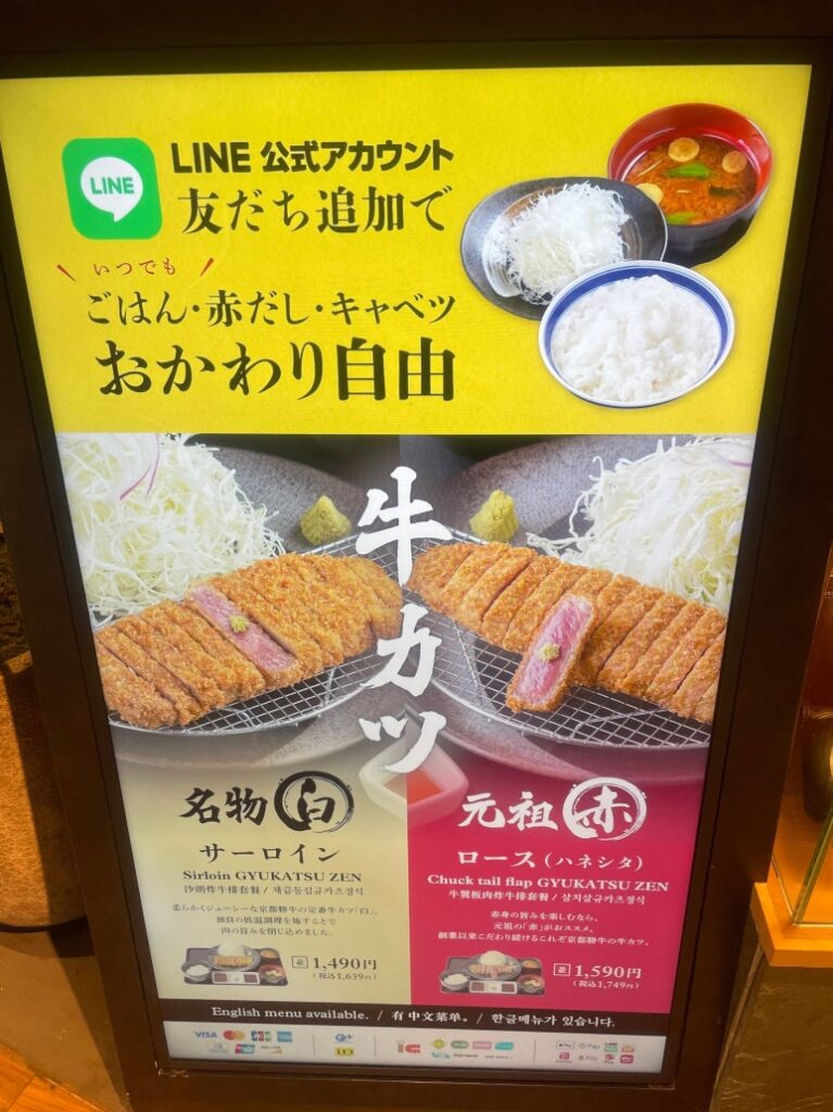 A digital sign showing that rice, soup, and cabbage refills are free with LINE friend registration Gyukatsu Kyoto Katsugyu