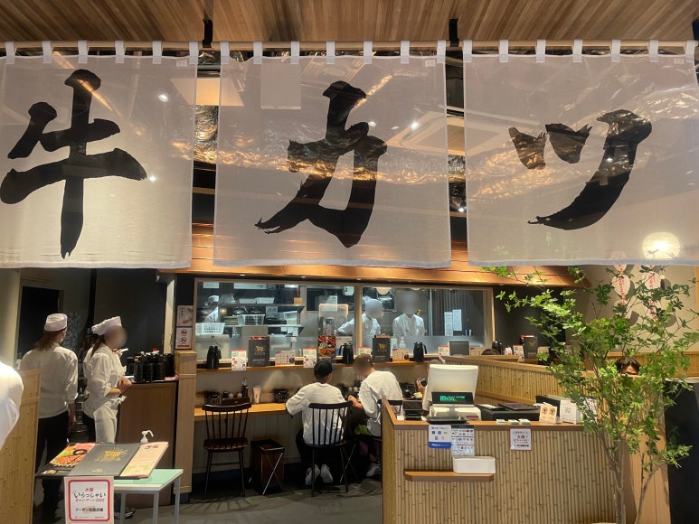 The entrance of Gyukatsu Kyoto Katsugyu with a noren curtain that reads “Gyukatsu”