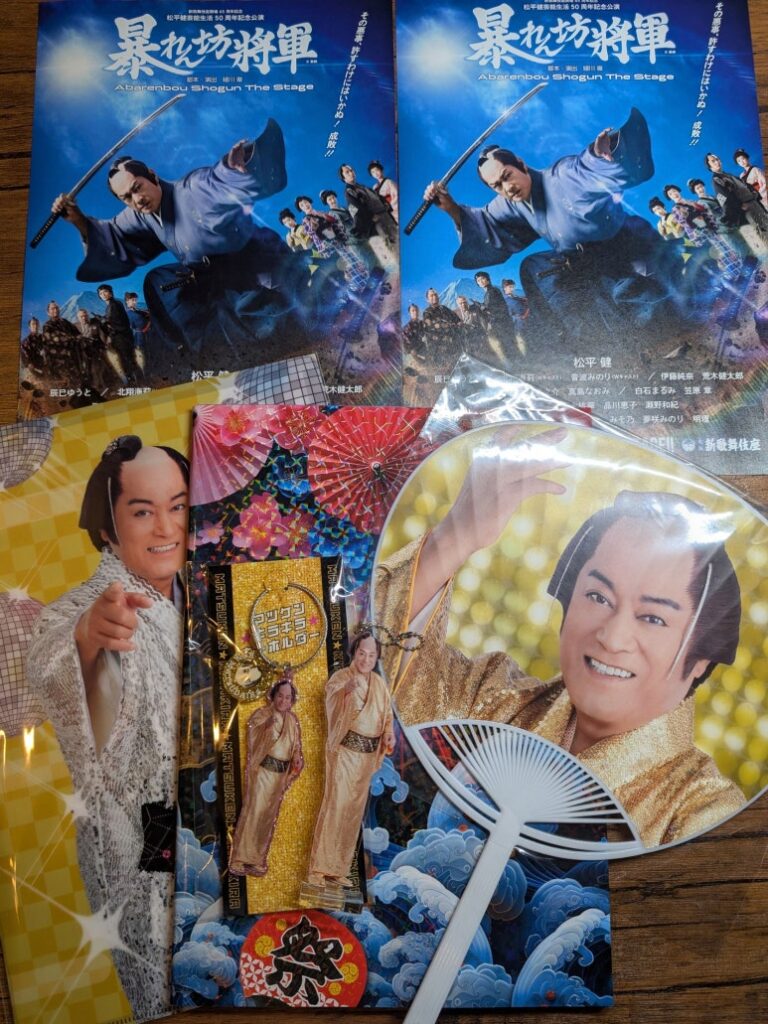 Goods purchased at the venue including pamphlet, program book, fan, and clear files