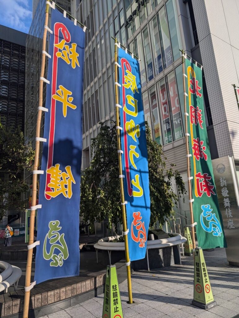 Vertical nobori flags in front of YUFURA displaying the names of Matsudaira Ken and other performers