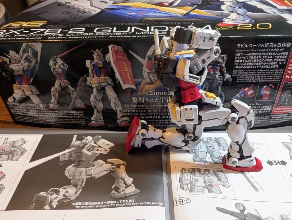 한쪽 무릎을 꿇고 등 뒤 빔 사벨을 꺼내는 RG 건담 완성 모습