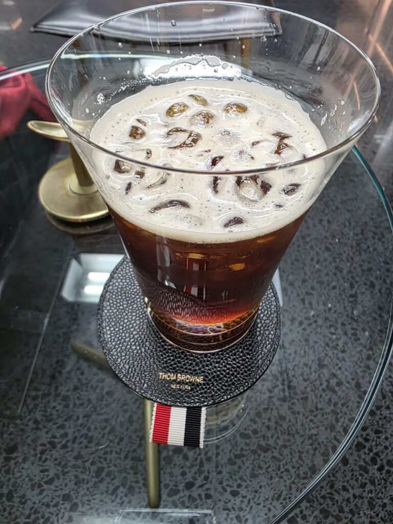 톰 브라운 코스터가 함께 제공된 아이스커피