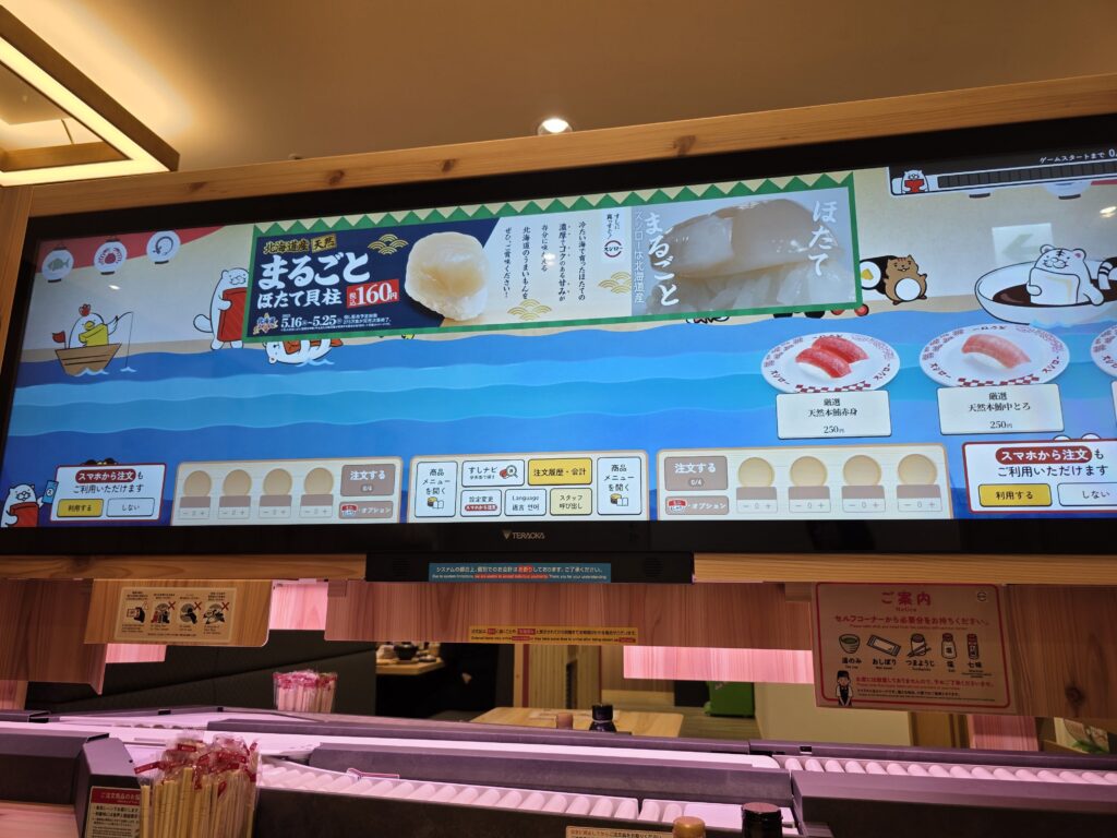 Large screen displaying rotating sushi for ordering