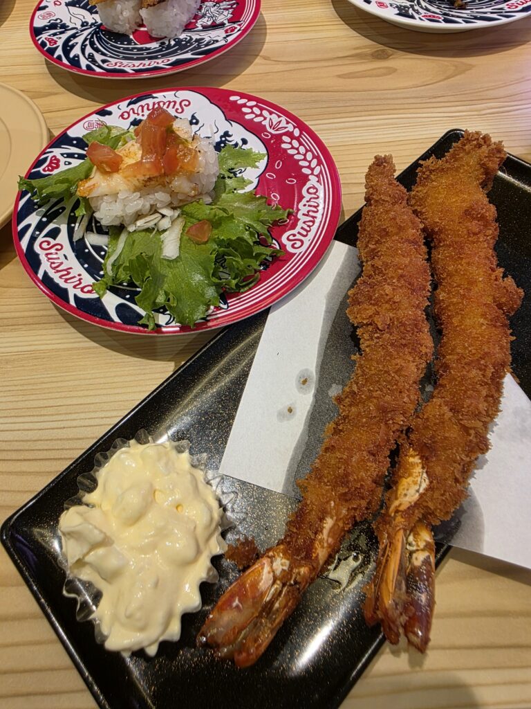 えび天ぷらとサラダ寿司が盛られた皿